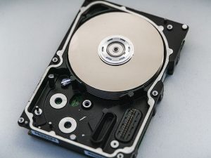 Black and chrome hard drive for a computer sitting on a white surface