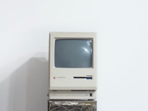 Old computer sitting alone in a white room