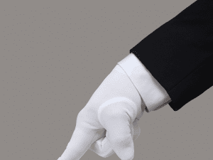 Person in a fancy suit with white gloves pressing down with their pointer finger on an unseen surface