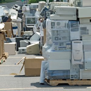 Old CPUs, monitors and printers loaded up on pallets at an electronics recycling event.